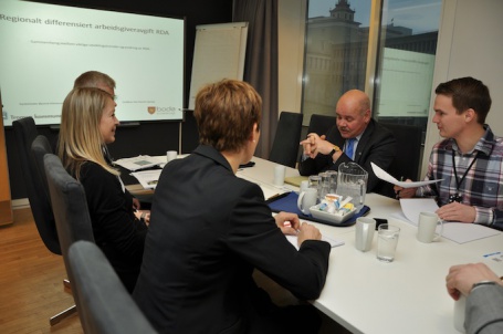 Representanter frå Bodø og Tromsø kommunar møtte statssekretær Jardar Jensen (blått slips) for å overrekkja ein rapport om differensiert arbeidsgivargiveravgift i Bodø og Tromsø i fjor. Foto: KMD.
